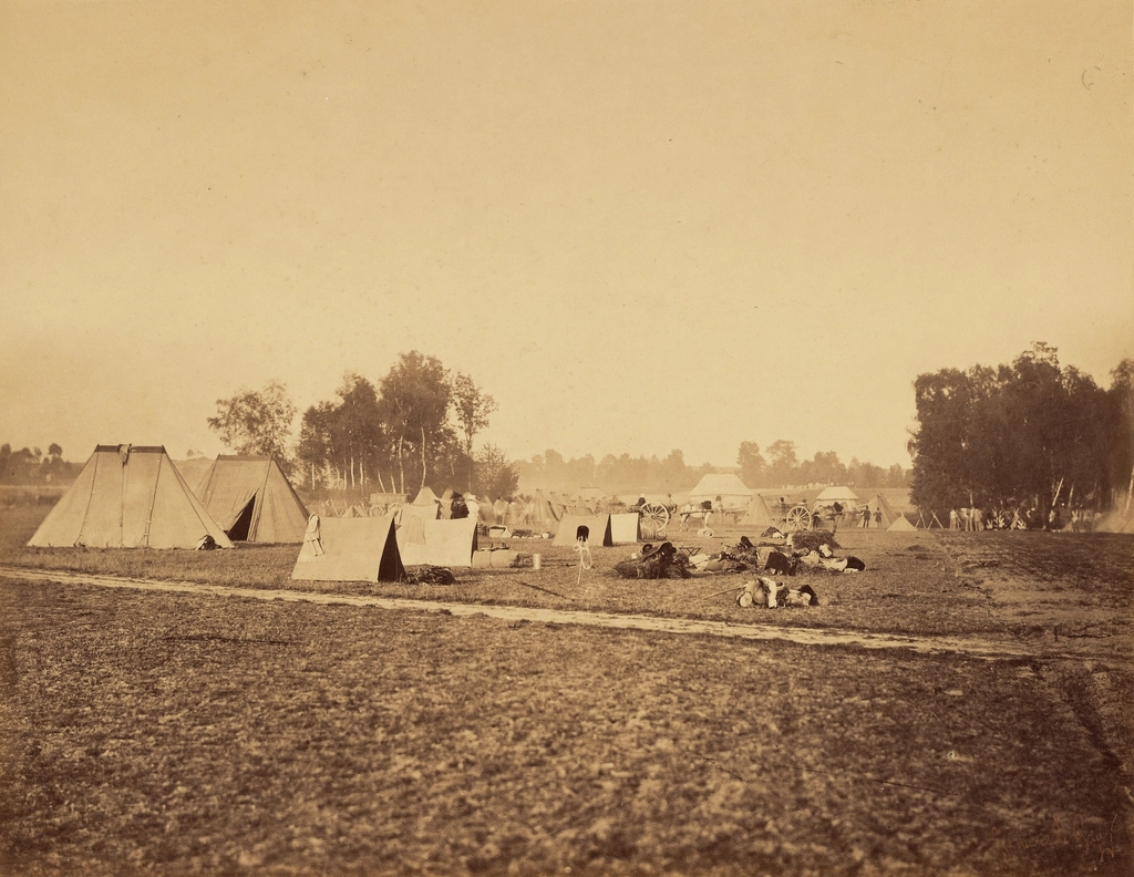 Row of military tents and field gear at a base camp
